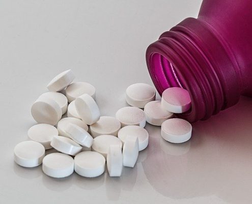 Pills scattered from a pink bottle. What you need to know about Benzo Detox at Home