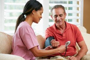 in home care nurse taking patient blood pressure