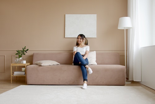 happy woman sitting on couch at home - kinkaids CA service locations