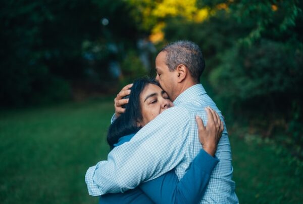 man and woman hugging out on the lawn for article how to treat cancer patients at home