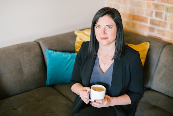 female executive holding coffee sitting on couch